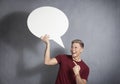 Joyful man pointing at blank speech ballon.