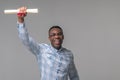 Joyful man raising up hand with paper bundle