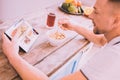 Joyful man searching on the Internet while having breakfast Royalty Free Stock Photo