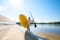 Joyful man is standing with a SUP board in his hands on the beach Royalty Free Stock Photo