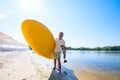 Joyful man is standing with a SUP board in his hands on the beac Royalty Free Stock Photo