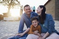 Happy family on the beach. Laughing dad, mom and little son in casual clothes on background of surfboards. Joyful young man Royalty Free Stock Photo