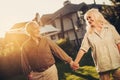 Joyful mature twosome on lawn fronting house