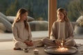 Joyful Middle-Aged Woman Enjoying Serene Yoga Session with Her Sister in the Comfort of Home