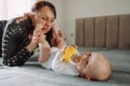 Joyful mom plays with her little son on the bed Royalty Free Stock Photo