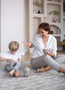 joyful mom and son getting ready for meditation, playing together sitting on the floor at home Royalty Free Stock Photo