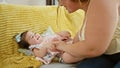 Joyful mother and daughter lying on sofa, laughing a lot while having tickle play at home Royalty Free Stock Photo