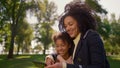 Joyful mother making selfie in park portrait. Gentle relations between mom kid.