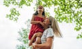 Joyful mother playing and riding on her shoulder her daughter in the park. Happy kid having fun with her mom enjoying the time Royalty Free Stock Photo