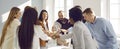 Joyful and motivated business colleagues make stack of hands during brainstorm in office.