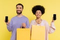 joyful multiethnic couple with shopping bags