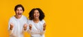Joyful multiracial couple rejoicing success, raising fists with excitement