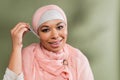 joyful multiracial muslim woman in pink