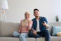 Joyful muslim couple watching funny TV programs