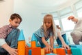 Joyful nice children building a tower from toys