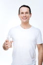 Joyful nice man holding a glass of water