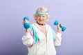 Cheerful elderly woman exercising with a pair of dumbbells and smiling Royalty Free Stock Photo