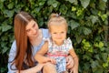 Joyful older sister holding younger sister, playing and laughing, having fun. Teen girl holding baby girl on summer day Royalty Free Stock Photo