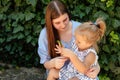 Joyful older sister holding younger sister, playing and laughing, having fun. Teen girl holding baby girl on summer day Royalty Free Stock Photo