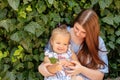 Joyful older sister holding younger sister, playing and laughing, having fun. Teen girl holding baby girl on summer day Royalty Free Stock Photo