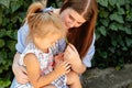 Joyful older sister holding younger sister, playing and laughing, having fun. Teen girl holding baby girl on summer day Royalty Free Stock Photo