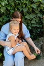 Joyful older sister holding younger sister, playing and laughing, having fun. Teen girl holding baby girl on summer day Royalty Free Stock Photo