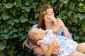 Joyful older sister holding younger sister, playing and laughing, having fun. Teen girl holding baby girl on summer day Royalty Free Stock Photo