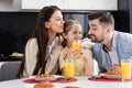 joyful parents embracing daughter during breakfast Royalty Free Stock Photo