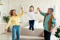 Parents Holding Daughter& x27;s Hands While Kid Jumping Having Fun Indoors Royalty Free Stock Photo
