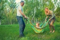 Joyful parents play with their little daughter in a park Royalty Free Stock Photo