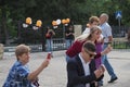 Joyful parents take pictures of their children on their mobile phone at the festival. Russia, Saratov - September. 2019