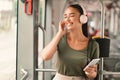 Joyful Passenger Lady Holding Cellphone Wearing Headphones Sitting In Tram Royalty Free Stock Photo