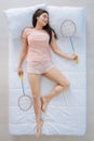 Joyful pleasant woman holding badminton rackets