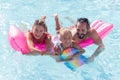 Joyful positive family swimming together in the pool