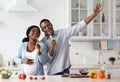 Joyful pregnant black couple having fun while cooking Royalty Free Stock Photo