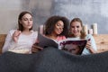 Joyful pretty girls discussing the magazine in the bed Royalty Free Stock Photo