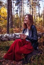 Joyful pretty young happy woman with a cup of tea poses in park. Cheerful girl likes to walk outdoors. Great weekend. Season Royalty Free Stock Photo