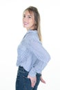 Joyful pretty young woman posing positively at camera dressed in casual shirt shows slim beauty against white background