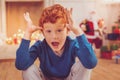 Joyful red-haired boy playing around on Christmas Eve