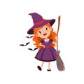 Joyful red-haired girl witch standing with broom and wearing purple dress and hat. Kid character in costume surrounded