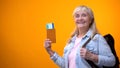 Joyful retiree woman showing passport and tickets, preparing for travel tour Royalty Free Stock Photo