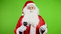 Joyful Santa Claus with glass of wine with toast congratulates on Christmas.