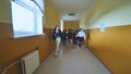 Joyful schoolgirls run after the end of the lessons in the school corridor. Royalty Free Stock Photo