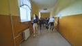 Joyful schoolgirls run after the end of the lessons in the school corridor. Royalty Free Stock Photo