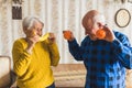 joyful senior Caucasian couple holding a banana and oranges medium shot indoor healthy eating concept Royalty Free Stock Photo