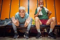 Joyful senior couple sitting in gym locker room, feeling energized and acting goofy, pre workout