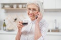Joyful senior housewife talking on phone in kitchen Royalty Free Stock Photo