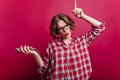 Joyful short-haired lady listening music with eyes closed on dark background. Indoor photo of chilling girl in glasses Royalty Free Stock Photo