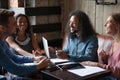 Joyful sincere young mixed race best friends communicating in cafe.