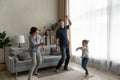 Joyful sincere young parents dancing with mall kid daughter.